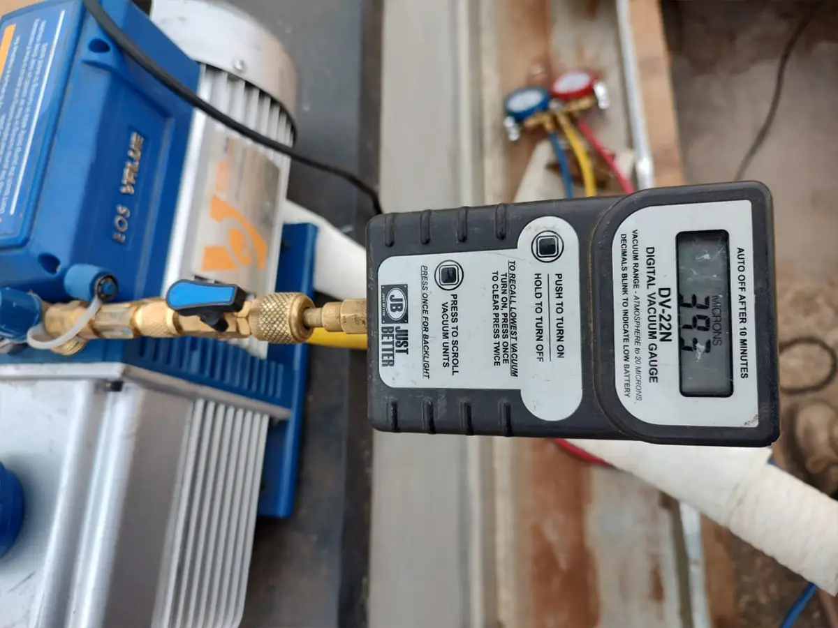 Medidor digital de vácuo conectado à bomba de vácuo durante instalação de ar-condicionado inverter em Campinas, garantindo vácuo profundo nas linhas frigorígenas pela DAPS Climatização.