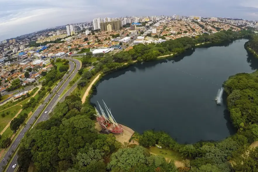 Vista aérea da Lagoa do Taquaral em Campinas, com a cidade e avenidas ao fundo, representando a região atendida pelos serviços de ar-condicionado da DAPS Climatização.