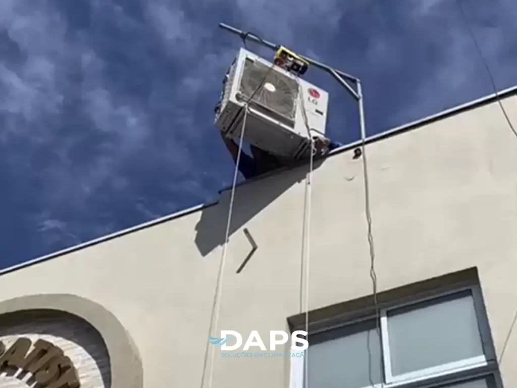 Unidade externa de ar-condicionado convencional instalada em fachada de edifício com céu azul ao fundo, mostrando tubuladações de conexão em Campinas, aplicação em igrejas.