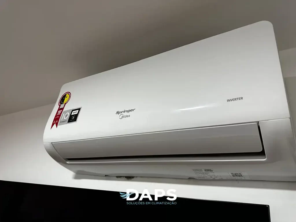 Ar-condicionado Springer Inverter instalado na parede interna de apartamento, mostrando o painel frontal com controles e logotipo da marca.