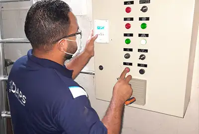 Técnico da DAPS ajustando parâmetros em painel de comando de ar-condicionado em Hortolândia
