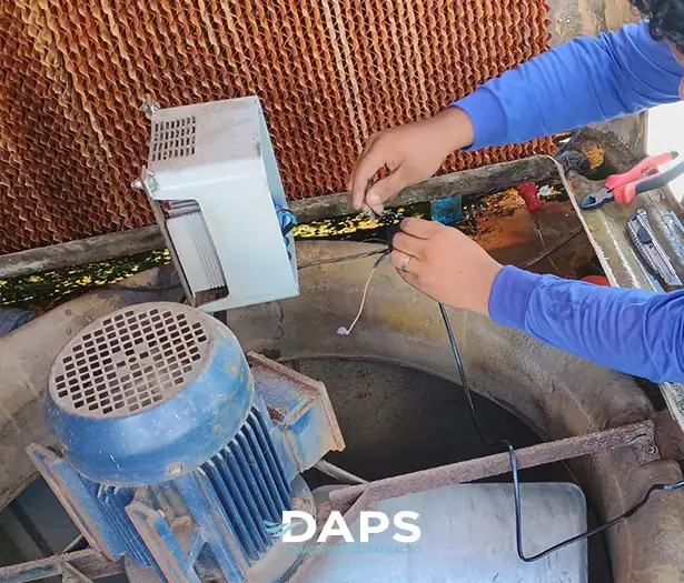 Técnico DAPS realizando manutenção interna em climatizador evaporativo em Campinas, ajustando fiação próxima ao ventilador e à bomba