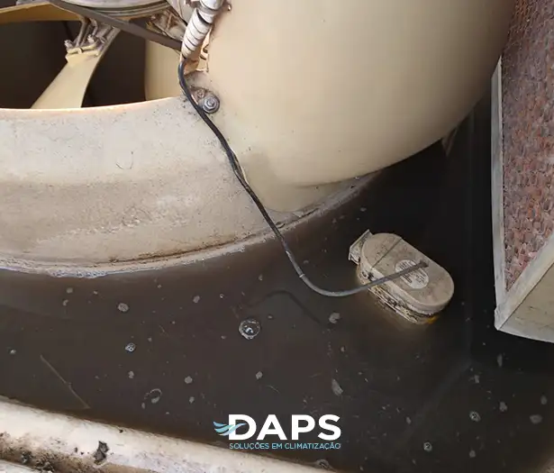 Manutenção preventiva de climatizador evaporativo DAPS mostrando drenagem e limpeza do reservatório com água escura