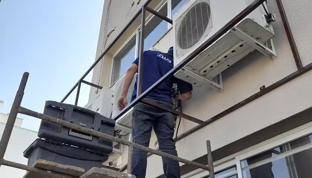 Técnico da DAPS Climatização realizando a manutenção de ar-condicionado em Campinas em uma unidade externa Elgin instalada em prédio comercial. Mostrando um Ar-Condicionado precisa de manutenção antes que ele pare
